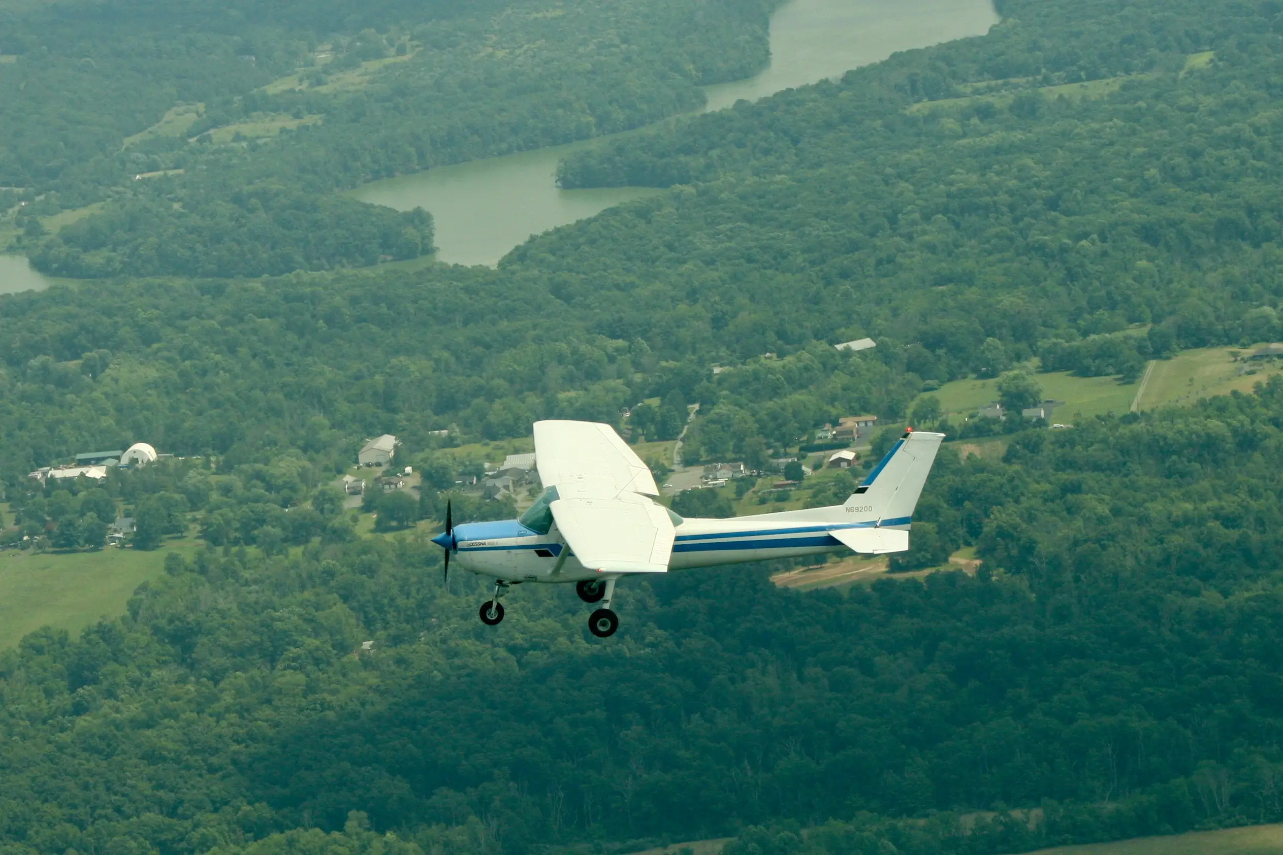 Pitcairn Flight Academy Cessna 152 flying over a river valley near Pottstown, PA