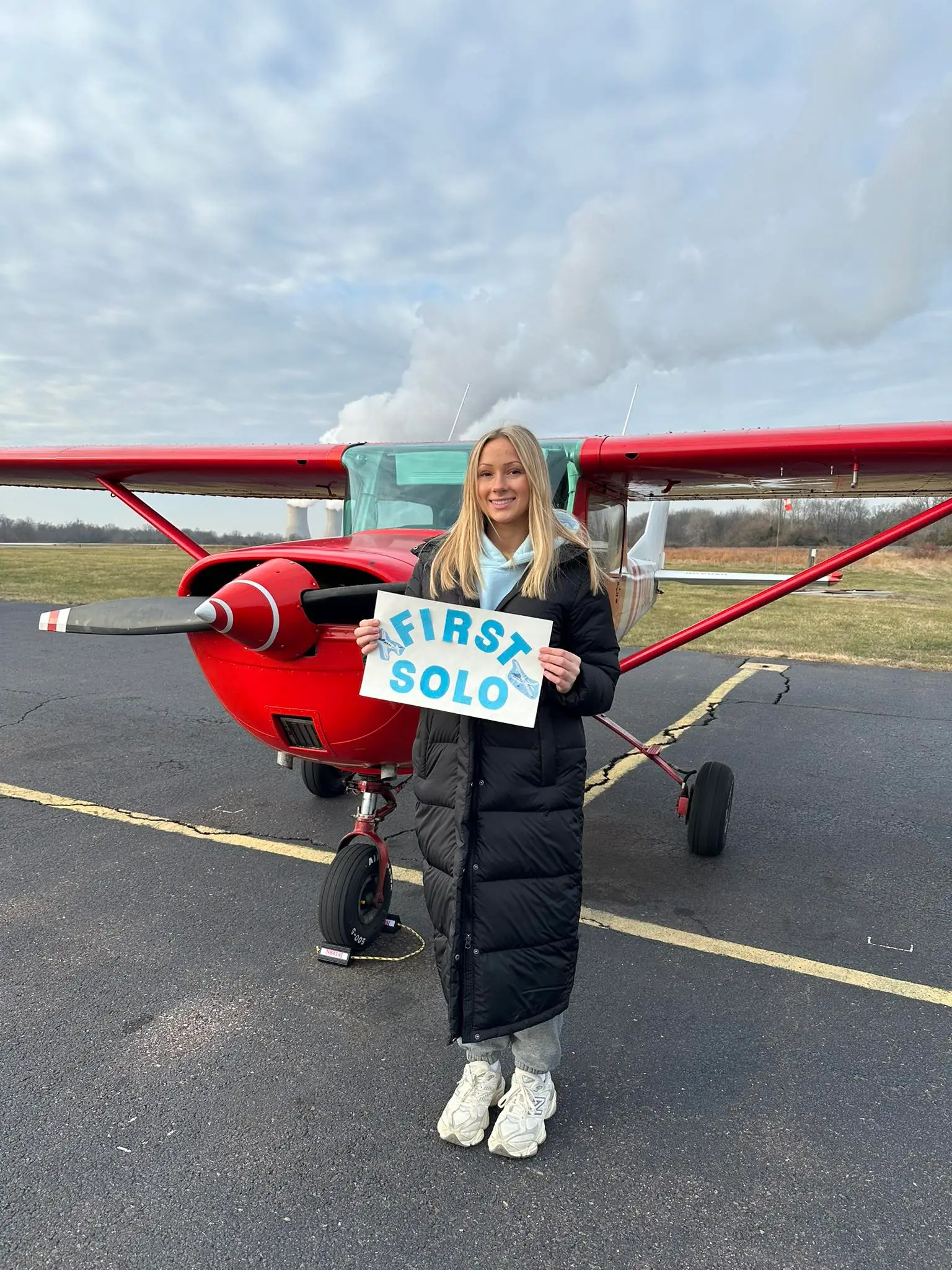 First solo woman student with red plane at Pitcairn Flight Academy in Pottstown, PA