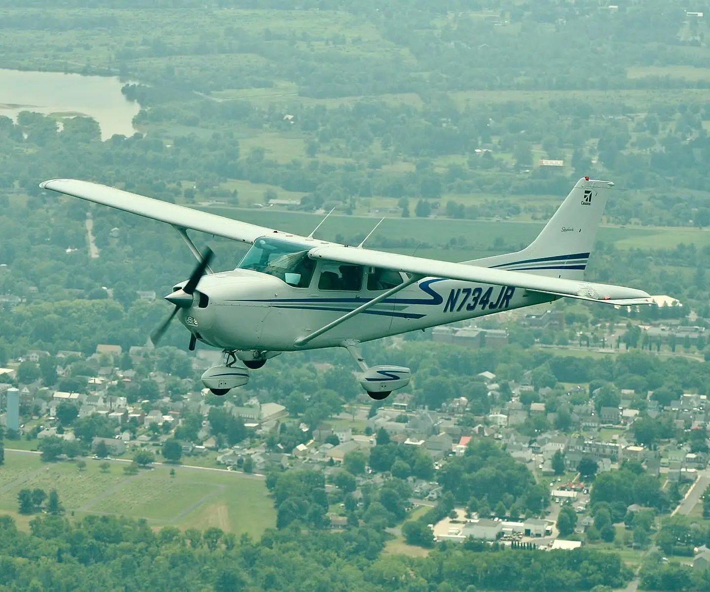 Plane flying over countryside at Pitcairn Flight Academy in Pottstown, PA pilot training